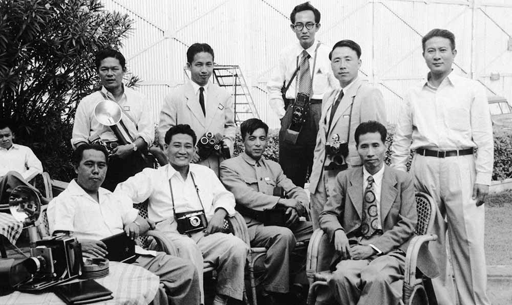 新華社記者錢嗣杰（站立者右二）在采訪會議開幕式后和外國記者在會場外休息。