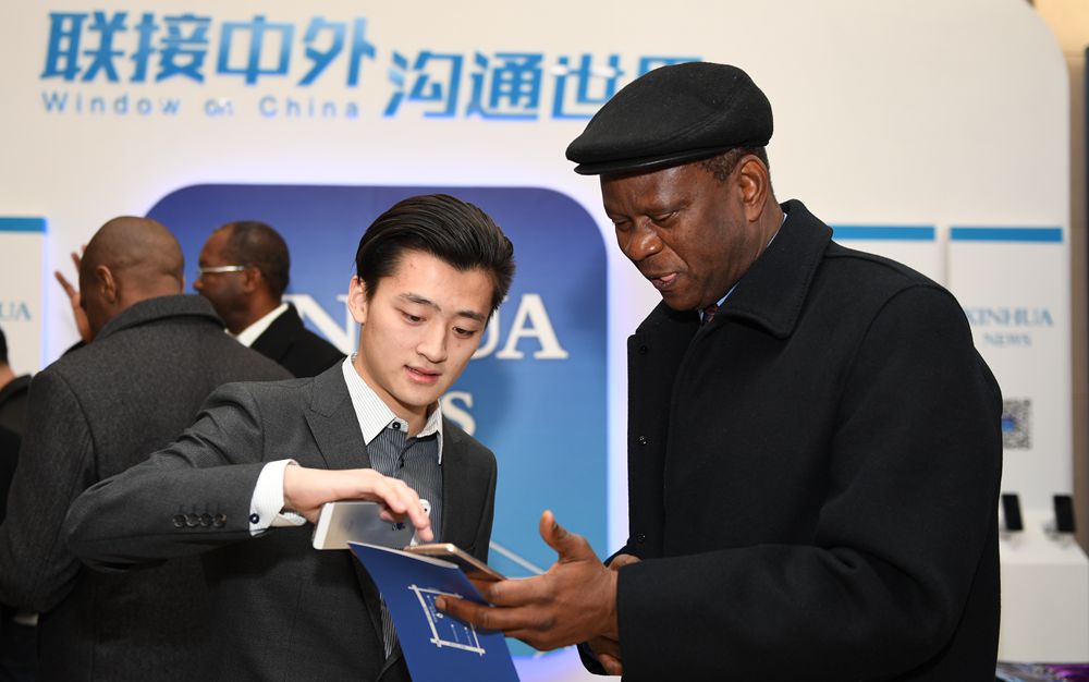 工作人員向嘉賓介紹新華社英文客戶(hù)端